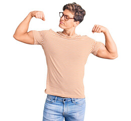 Fototapeta premium Young handsome man wearing casual clothes and glasses showing arms muscles smiling proud. fitness concept.