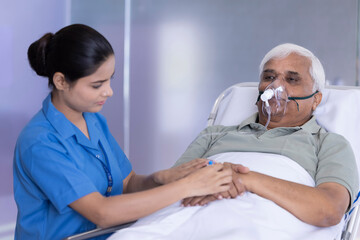 Fototapeta premium Female nurse injecting needle in hand of elderly patient at hospital 
