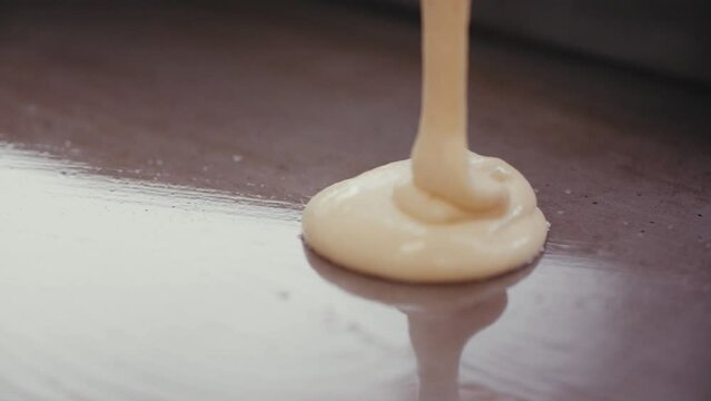 Closeup Of Pouring Pancake Batter On The Stove