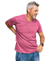 Middle age grey-haired man wearing casual clothes suffering of backache, touching back with hand, muscular pain