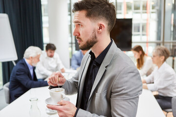 Young business man drinks an espresso