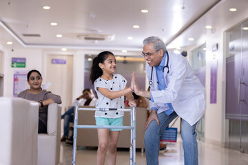 Doctor giving high five disable girl at hospital