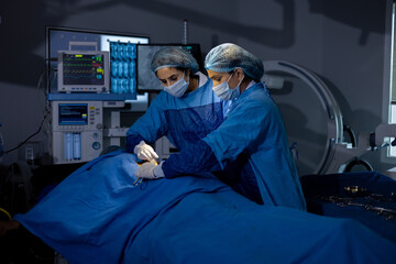 Two female surgeons performing surgery at hospital operating room
