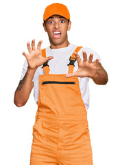 Young handsome african american man wearing handyman uniform afraid and terrified with fear...