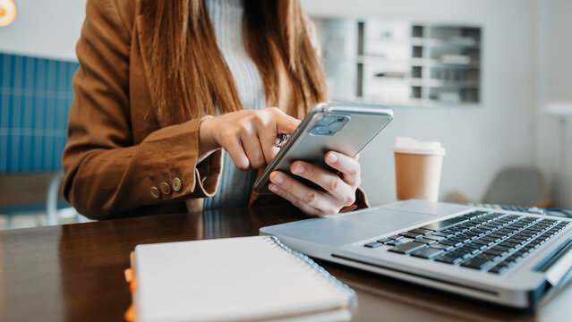 Businesswoman hand working digital marketing media in virtual screen with mobile phone and modern compute with VR icon diagram at office in morning light