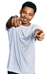 Young african american man wearing casual white t shirt pointing to you and the camera with fingers, smiling positive and cheerful