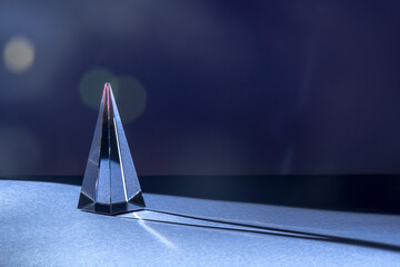 Minimal nightlife concept with reflective glass prism on dark purple blue background. Luxury, fantasy, surreal crypto aesthetics. Futuristic magic cristal.