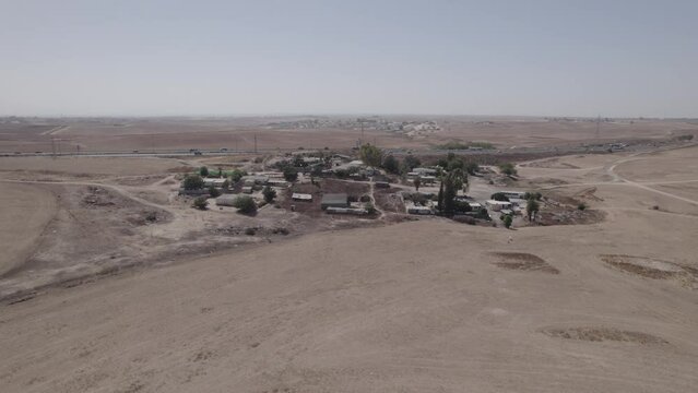 Parallax photography of houses without a permit in a remote and desert area, near a highway, with dry land without crops(D-LOG)