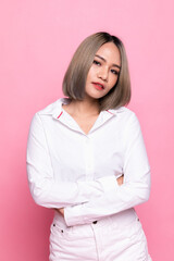 Beauty, people emotions and summer leisure concept. Asian girl in white shirt, cross arms chest, smiling happy at camera, standing pink background