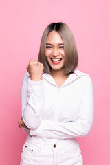 Fototapeta premium Portrait attractive asian woman feeling happy and posing fighting in front of a bright pink background.