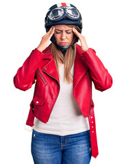 Young beautiful woman wearing motorcycle helmet suffering from headache desperate and stressed because pain and migraine. hands on head.