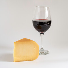 Smoked goat cheese and red wine on white background.
