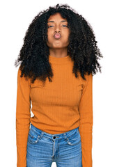 Young african american girl wearing casual clothes puffing cheeks with funny face. mouth inflated with air, crazy expression.