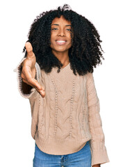 Young african american girl wearing casual clothes smiling friendly offering handshake as greeting and welcoming. successful business.