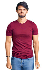 Fototapeta premium Handsome hispanic man wearing casual clothes puffing cheeks with funny face. mouth inflated with air, crazy expression.