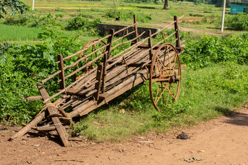 A traditional bullock cart on village road of Bengal. Paddy field on backside side of the road and small plateau hill in background.