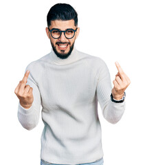 Young arab man with beard wearing elegant turtleneck sweater and glasses showing middle finger...