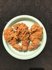 Floured fried chicken Photographed on a green plastic plate isolated on a dark background
