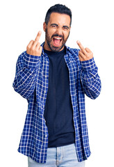 Young hispanic man wearing casual clothes showing middle finger doing fuck you bad expression,...