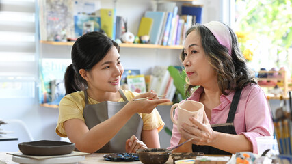 Ceramists business owners are making craft for sale in handmade potter retail store. Indoors lifestyle activity, handicraft, hobbies concept