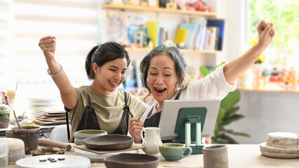 Shot of exited craft pottery shop owners are celebrating after finish big order from customer....