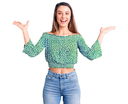 Young beautiful girl wearing casual t shirt celebrating victory with happy smile and winner expression with raised hands