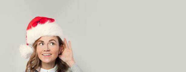 Fototapeta premium Christmas and New Year party concept. Happy woman listening - holiday is coming!