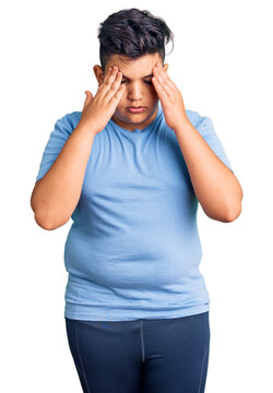 Little boy kid wearing sports workout clothes with hand on head for pain in head because stress. suffering migraine.