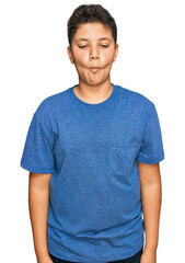 Teenager hispanic boy wearing casual clothes making fish face with lips, crazy and comical gesture. funny expression.