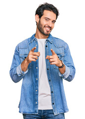 Young hispanic man wearing casual clothes pointing fingers to camera with happy and funny face. good energy and vibes.