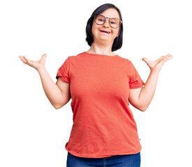 Brunette woman with down syndrome wearing casual clothes and glasses celebrating victory with happy smile and winner expression with raised hands