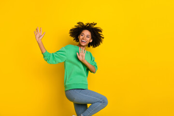 Portrait of charming peaceful lady raise hands look copyspace dance isolated on yellow color background
