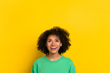 Photo of charming excited woman wear green pullover looking up empty space isolated yellow color background