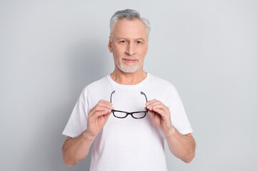 Photo of aged man hold specs enjoy new optics shopping sales isolated on silver color background