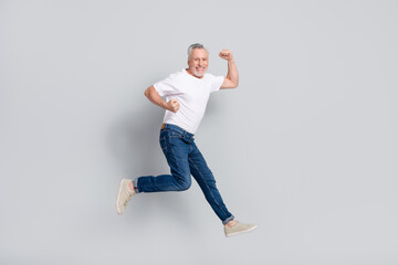 Fototapeta na wymiar Full length body size view of attractive cheery sportive man jumping running strength isolated over grey pastel color background