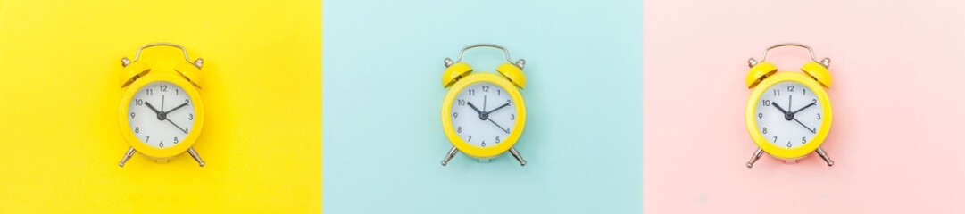 Ringing twin bell vintage classic alarm clock Isolated on colourful yellow blue pink background....
