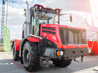 Fototapeta premium Red heavy duty wheeled tractor on a parking lot