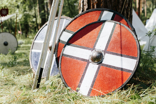 Close-up of round wooden shields and spears in medieval campground outdoors