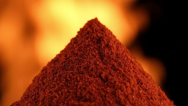 Smoked paprika spice in spoon, over open fire