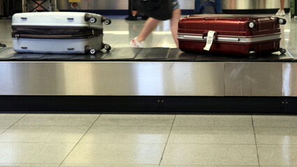 Luggage, suitcase on the conveyor belt in an arrivals lounge of the airport.  Traveler suitcases in airport terminal. 