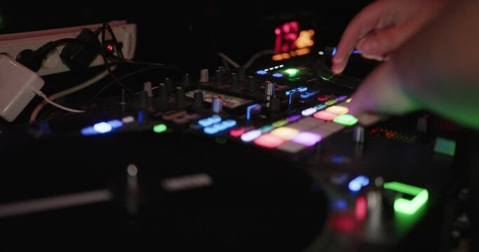dj is playing on a DJ Controller in a club