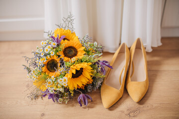 bridal bouquet. Yellow bridal shoes next to a bridal bouquet of sunflowers. Yellow bouquet and...