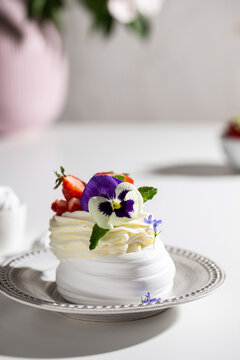 Meringue dessert with berries and flowers for breakfast