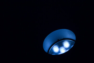 Modern floor led lamp for outdoors use, in circular shape against dark background - concept with copy space