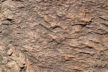 Raw granite rock texture background. Fragment of natural stone wall.