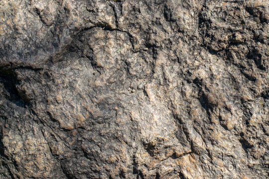 Raw granite rock texture background. Fragment of natural stone wall.