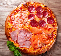 pizza with Mozzarella cheese, ham, shrimp, salami. Italian pizza on wooden table background