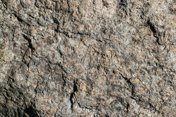 Raw granite rock texture background. Fragment of natural stone wall.