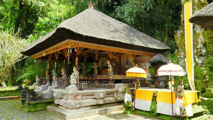 schöner hinduistischer Tempel "Gunung Kawi Sebatu" dekoriert mit hl. Schirmen in Bali bei Ubud in den Tropen