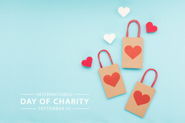 International Day of Charity, 5 September. Red White Hearts and Bags on Blue Background.